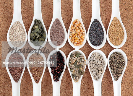 Seed food selection in white porcelain bowls over cork background.