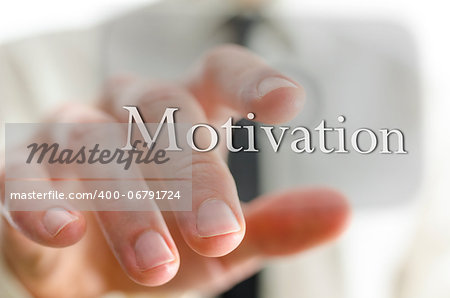 Businessman hand pointing at motivation button on a virtual screen.