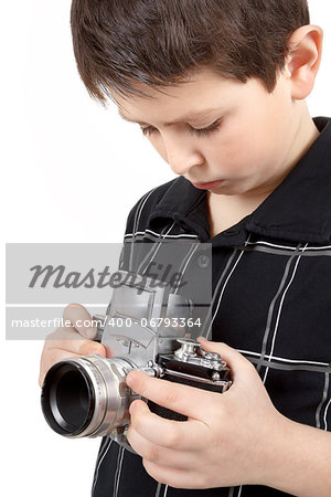 young boy with old vintage analog SLR camera looking to viewfinder