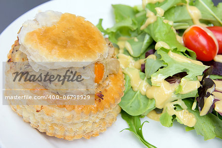 Chicken Pot Pie with Leafy Green Vegetables Tomatoes and Salad Dressing Closeup