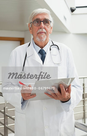 Doctor holding file in hospital corridor