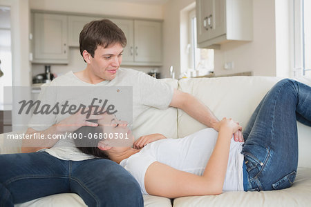 Prospective parents lying on the couch together in living room