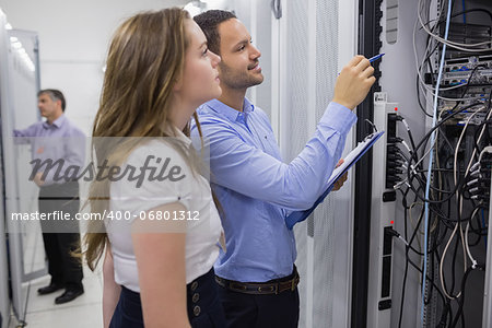 Technicians doing maintenance on servers with a clipboard