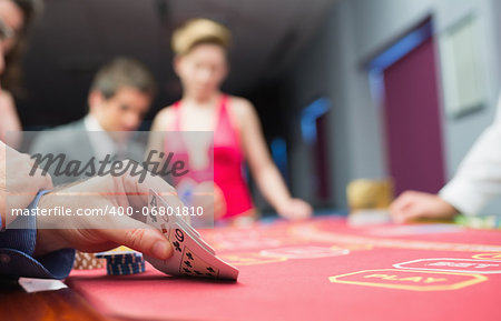 Man lifting hand of poker in casino