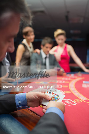 Man looking at his cards in poker game at casino