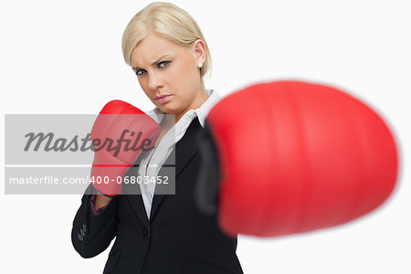 Serious businesswoman with red gloves fighting against white background