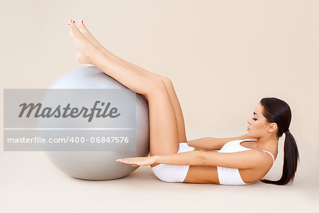 Cute woman doing abdominal muscles with fitness ball