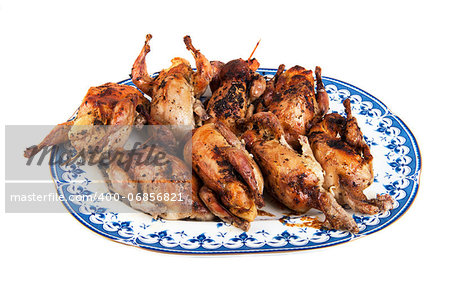 Big plate full of freshly roasted quails isolated on white