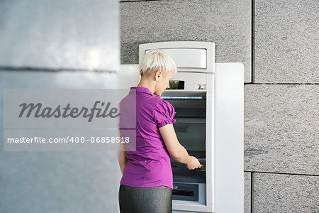 business woman withdrawing cash at bank atm