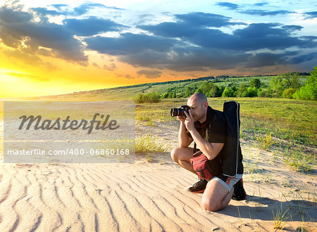 Man photographs the sunset in the desert