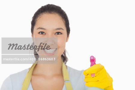 Smiling woman in rubber gloves with spray bottle