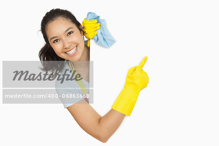Woman in rubber gloves and apron pointing to the white surface she is behind