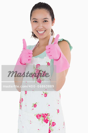 Smiling woman wearing rubber gloves giving thumbs up on a white background