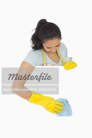Smiling woman in rubber gloves cleaning white surface
