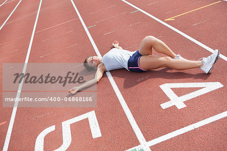 Woman lying down taking break on track field