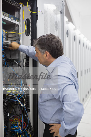 Technician controlling the server case and adjusting the cables