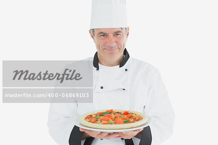 Portrait of mature male chef holding pizza over white background