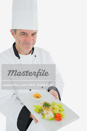 Portrait of happy male chef offering fresh prepared meal standing over white background