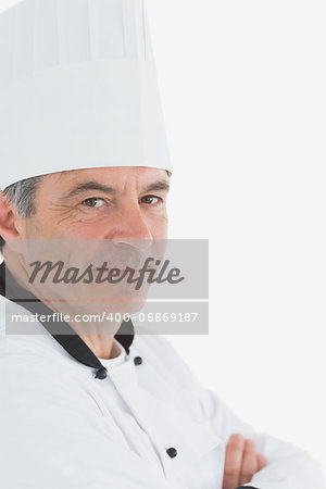 Portrait of confident male chef with arms crossed against white background