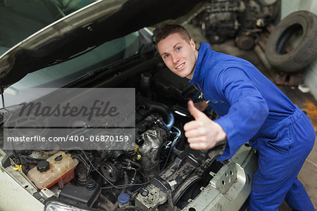 Portrait of car mechanic gesturing thumbs up in workshop