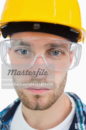 Closeup portrait of architect wearing protective eyewear and hardhat over white background