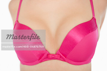 Extreme closeup of woman in pink bra over white background