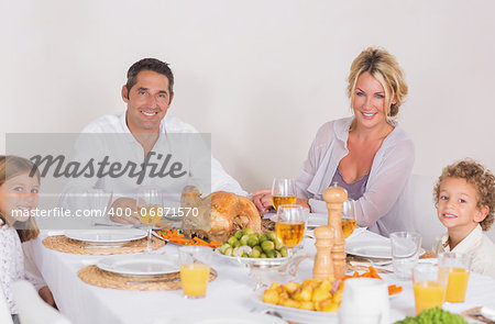 Family sitting on table to eat a turkey