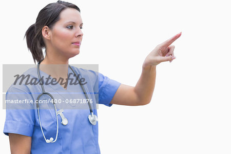 Female surgeon pointing at invisible screen against white background