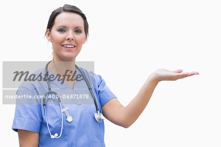 Portrait of female surgeon holding out open palm against white background