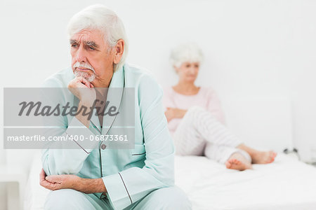 Elderly couple not speaking in bedroom