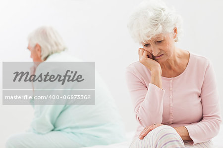 Elderly couple not talking to each other in bedroom