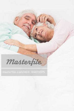 Elderly couple having a cuddle in bed