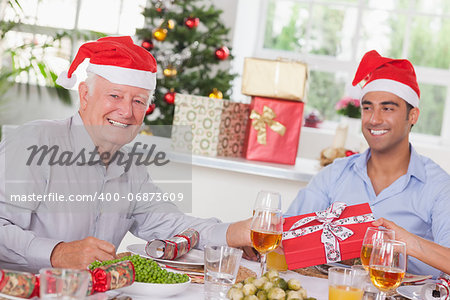 Family swapping christmas presents at christmas dinner