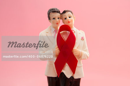 Gay groom cake toppers with red awareness ribbon on pink background