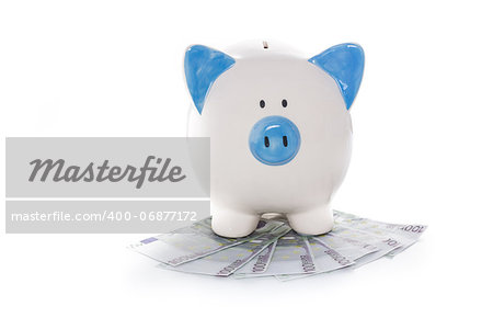 Hand painted blue and white piggy bank on pile of euros on white background