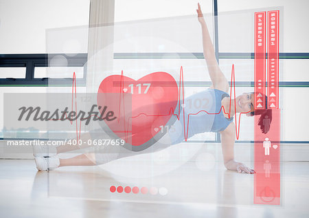 Young woman doing yoga while looking at futuristic interface showing her heartbeat