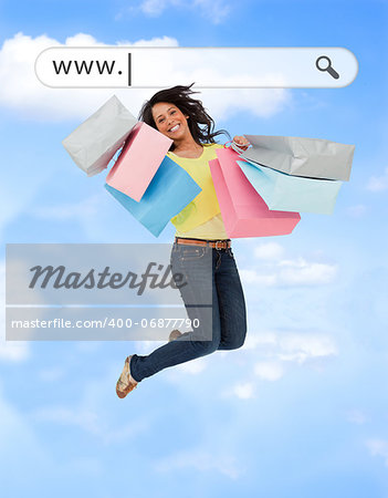 Happy girl jumping with her shopping bags under address bar on blue sky background