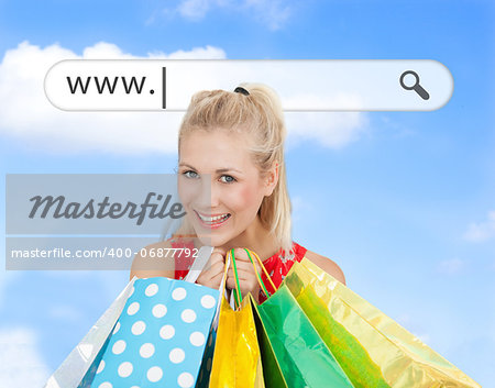 Happy blonde with her shopping bags under address bar on blue sky background