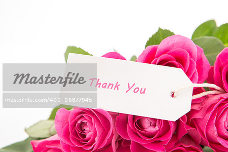Close up of a bouquet of pink roses with a thank you card on a white background
