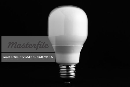 Energy saving bulb on black background standing