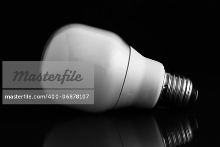 Energy saving bulb laying on its side on black background