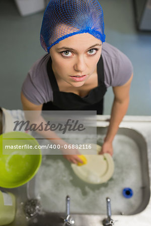 Frowning woman looking up from doing the washing up