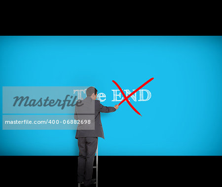Businessman crossing out the word end on a giant blue wall
