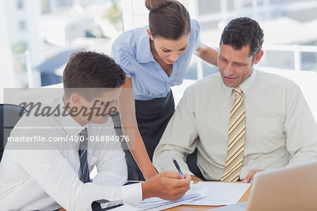 Businessmen and a businesswoman working together in the office