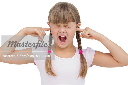 Funny little girl clogging her ears and wincing on white background