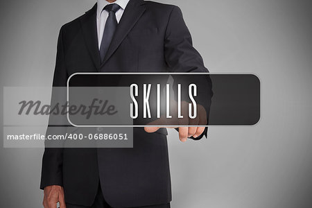 Businessman selecting label with skills written on it on grey background