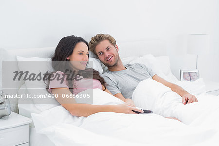 Couple in bed watching TV together