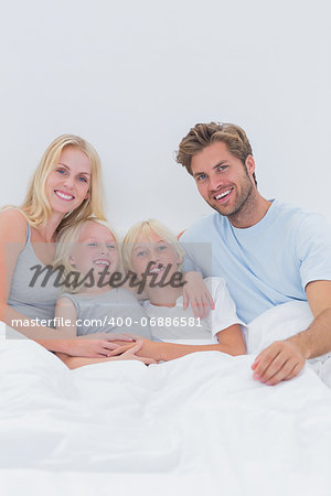 Portrait of a happy family relaxing in bed