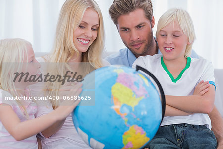 Smiling family with globe in sitting room