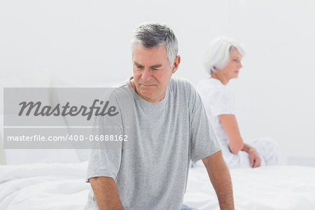 Upset couple sitting on bed after a dispute